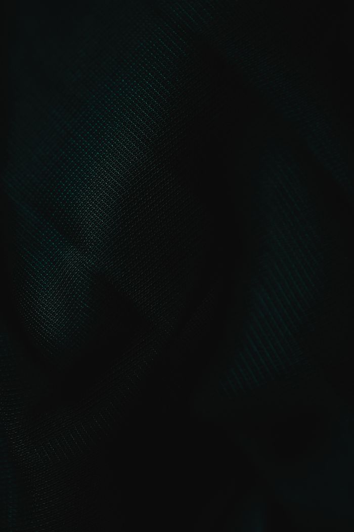 A dark fabric texture showcasing intricate patterns under subdued lighting.